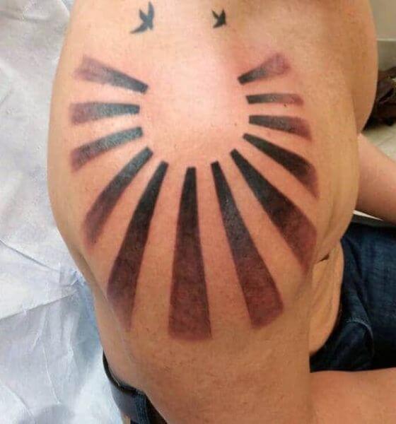 Faded rising sun tattoo design on shoulder