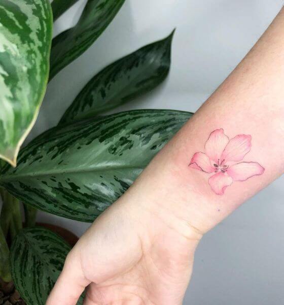 Single cherry blossom tattoo on wrist