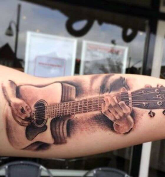 Rock guitar style tattoo on triceps