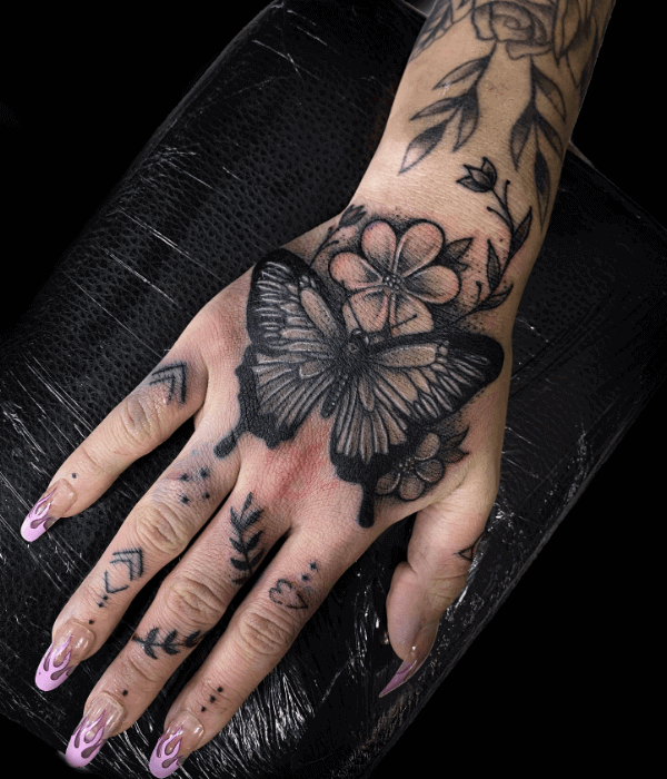 Blackwork butterfly hand tattoo