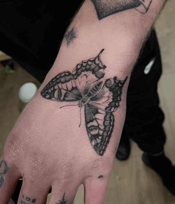 Dramatic black and grey butterfly hand tattoo