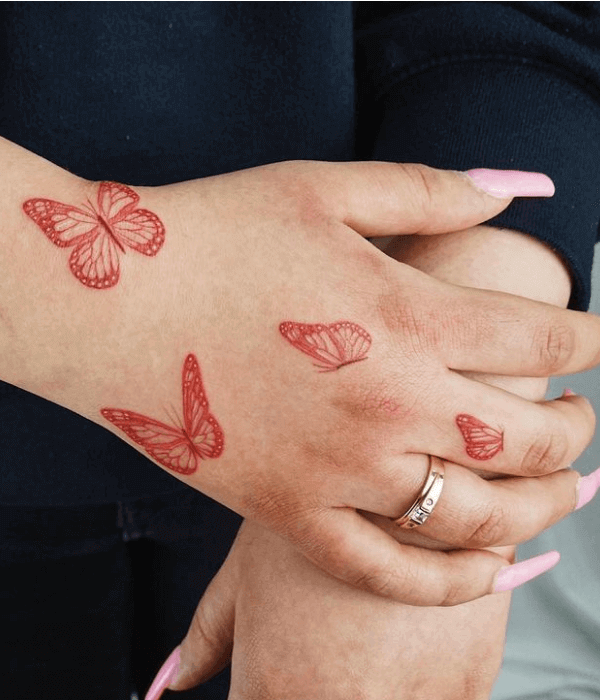 Fine line butterfly hand tattoo