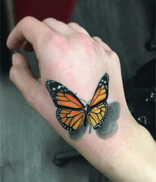 Realistic black and grey butterfly hand tattoo