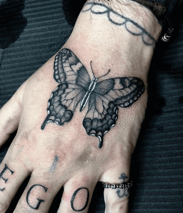 Realistic black and grey butterfly hand tattoo