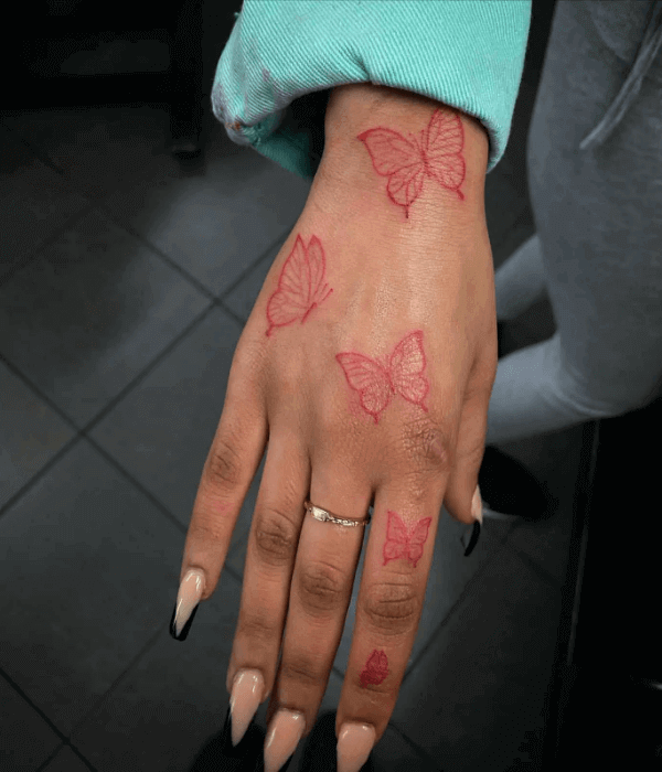 Fine line butterfly tattoo in red ink