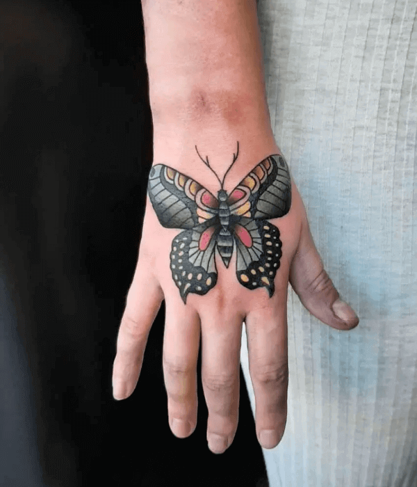 Whimsical butterfly wings tattoo on hand