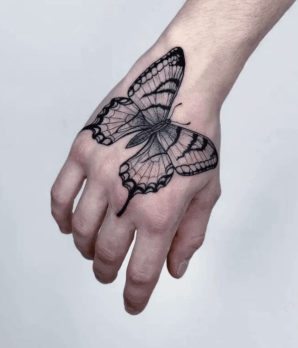 Whimsical butterfly wings tattoo on hand