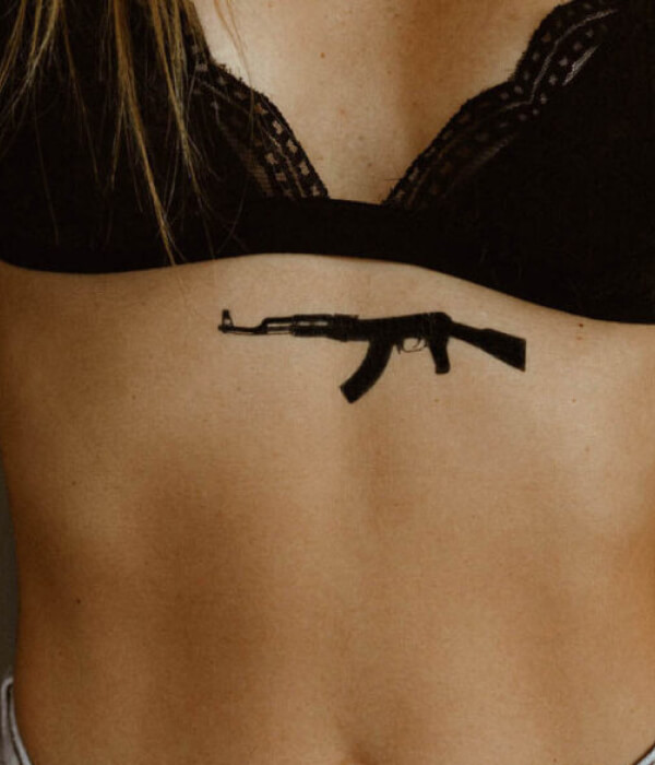 Black AK 47 tattoo on the waist