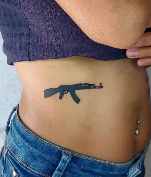 Black AK 47 tattoo on the waist