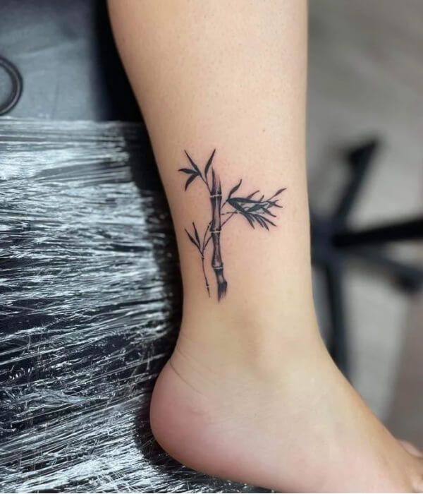 Black ink bamboo tree tattoo on foot