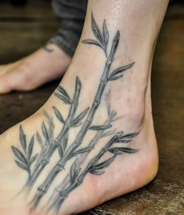 Black ink bamboo tree tattoo on foot