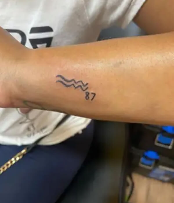 Minimalistic Aquarius tattoo on the wrist