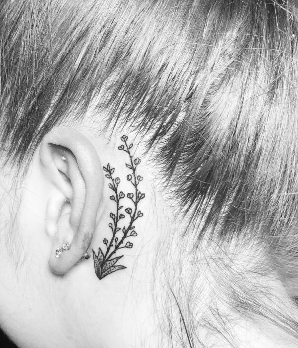 A small plant near the ear tattoo