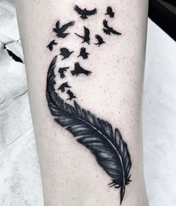 Black raven tattoo with a feather