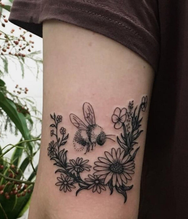 Daisy tattoo with a bee