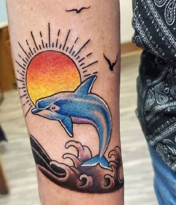 Dolphin tattoo with sunset