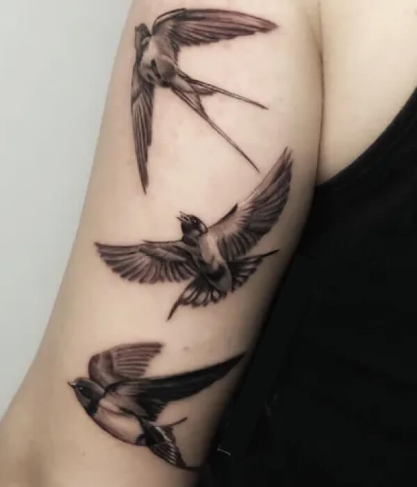 Swallow bird tattoo carrying a cross