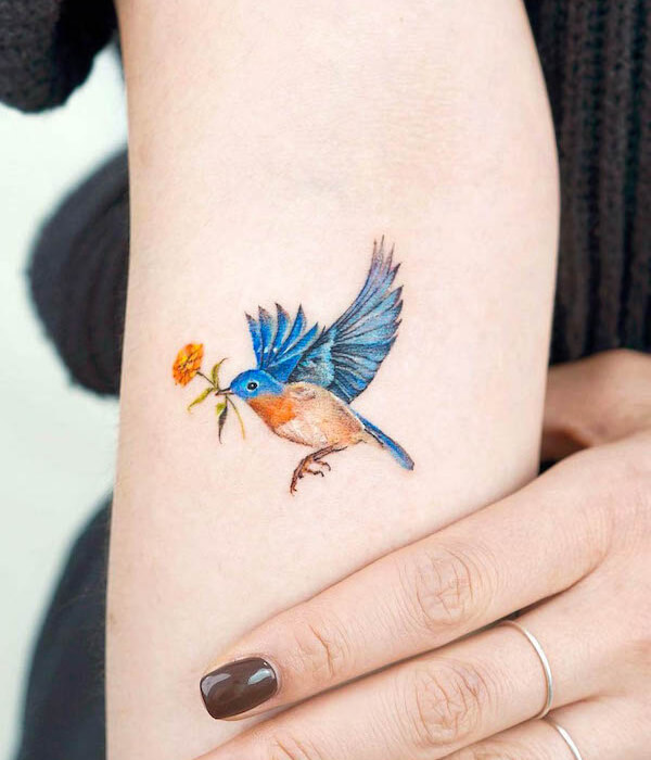 Swallow bird tattoo carrying a flower
