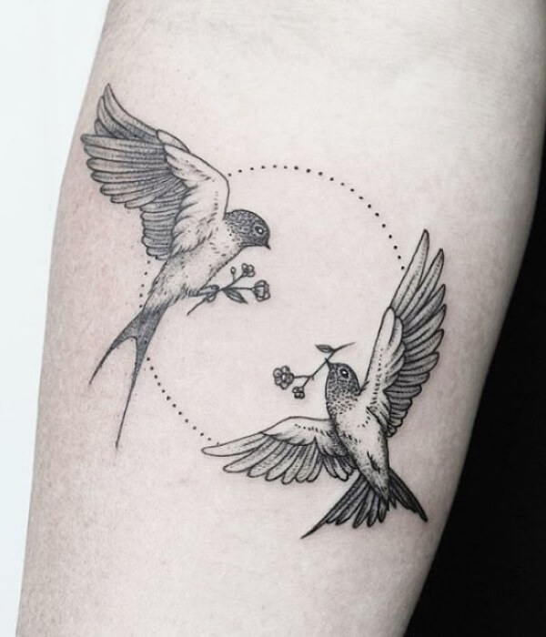 Swallow bird tattoo carrying a flower