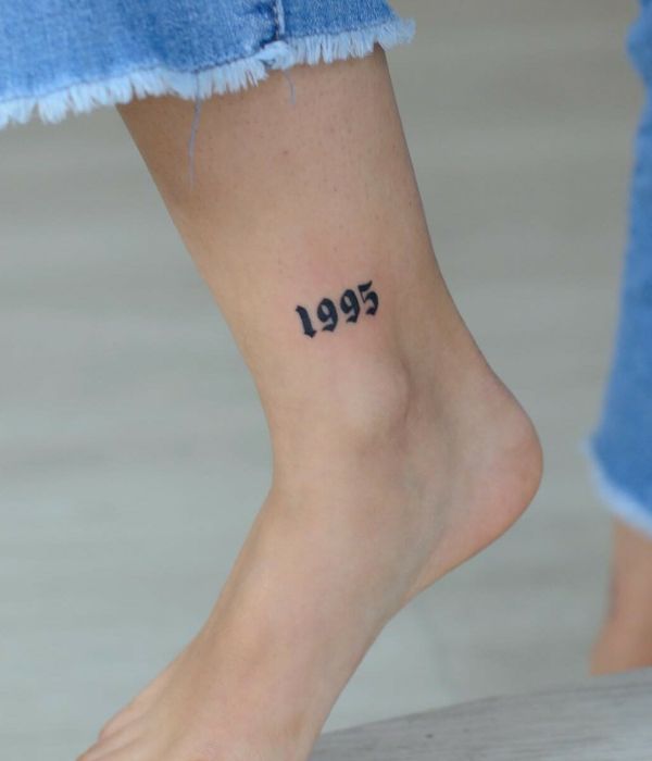 Small birth year foot tattoo