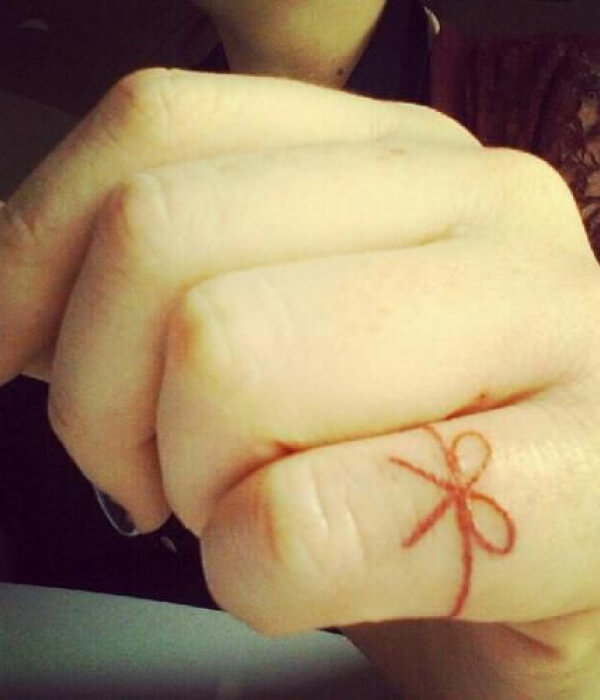 Red Ribbon Tied in Bow Around Ring Finger