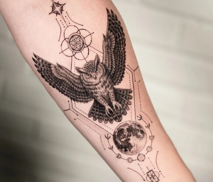 Minimalist Animal Symbol Tattoo - Trending Tattoo Detailed owl tattoo with spread wings, combined with geometric patterns, moon phases, and celestial symbols on the forearm.