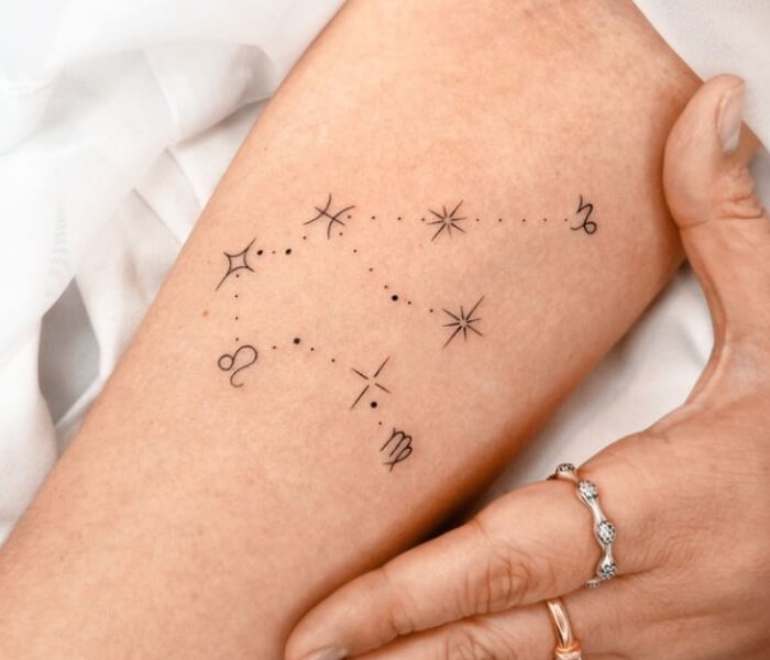 Minimalist Constellation Tattoo - Trending Tattoo Minimalist constellation tattoo with fine-line stars and zodiac symbols arranged delicately on the forearm.