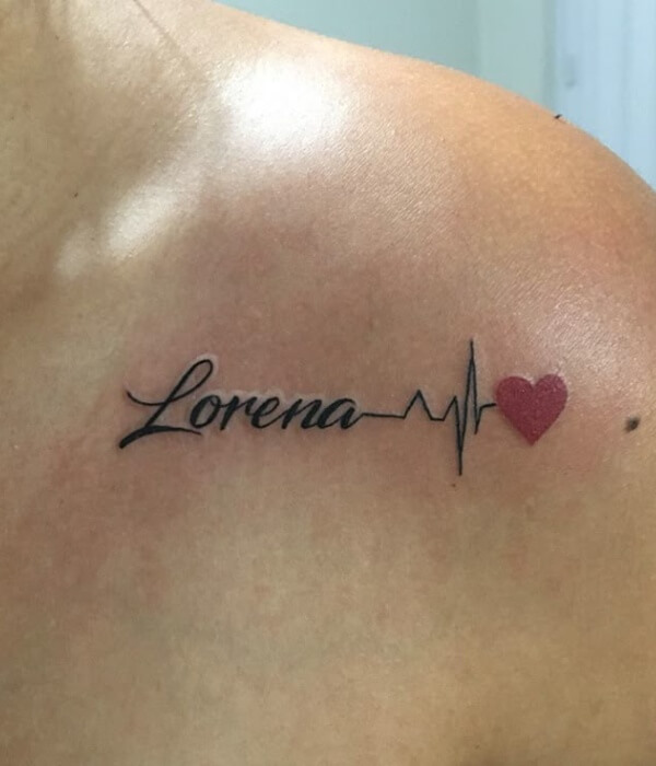Name tattoo reading “Lorena” in elegant cursive, combined with a heartbeat line and a small red heart, inked in black and red on the collarbone area.