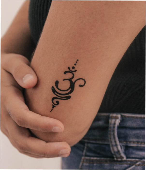 AUM Tattoo 1 - Trending Tattoo Minimal Om symbol tattoo on inner arm.