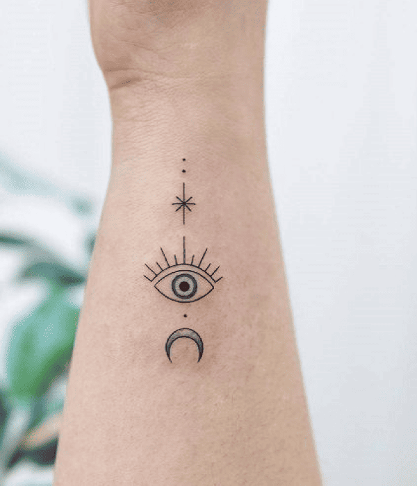 Minimalist celestial eye tattoo on the inner forearm with star and crescent moon, symbolizing intuition, protection, and spiritual awareness.