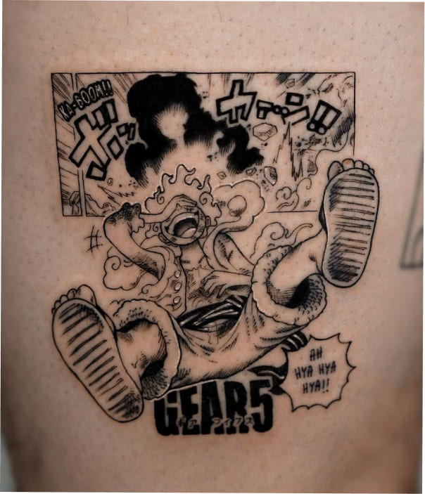 A dynamic black-and-grey manga-style tattoo of Luffy in his Gear 5 form from One Piece, depicting him laughing joyfully mid-air with iconic "Gear 5" lettering, Japanese sound effects, and a stylized explosion background.