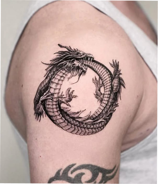 Circular dragon tattoo on upper arm, black ink design